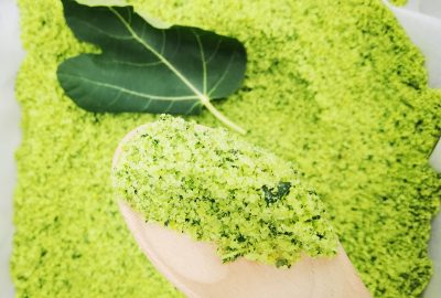 Zelena aromatizirana sol na drvenoj žlici i list smokve