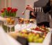 Osoba poslužuje zalogaje na catering stolu