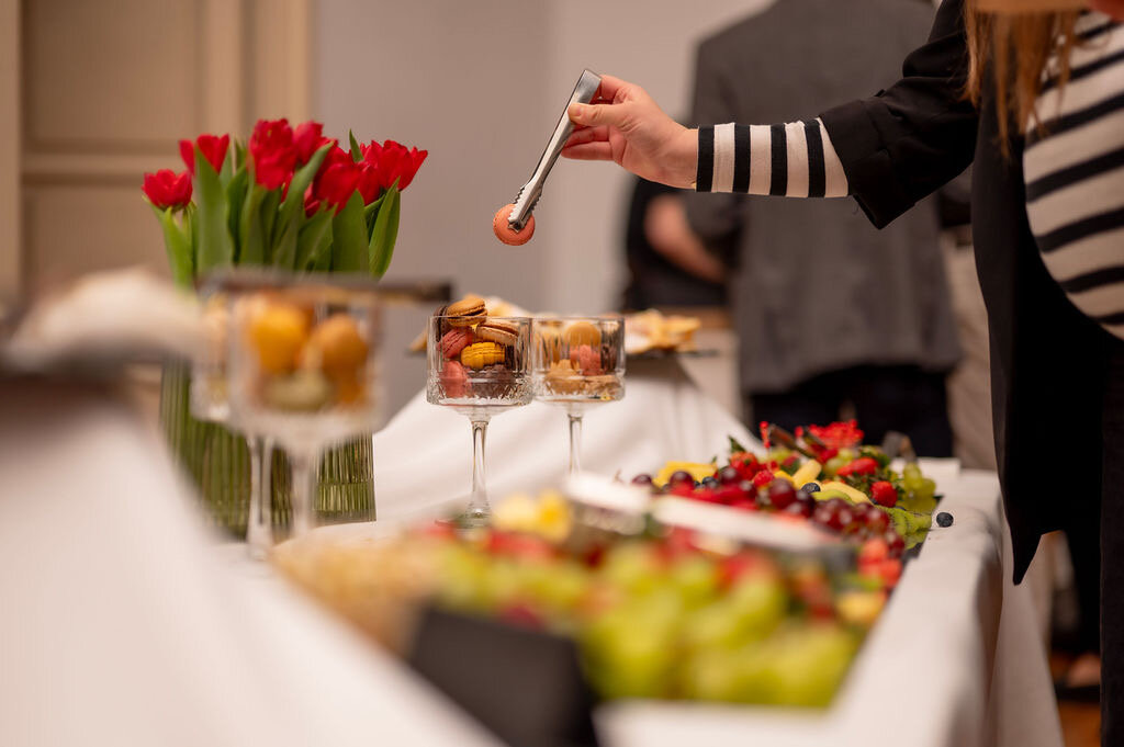 Osoba poslužuje zalogaje na catering stolu