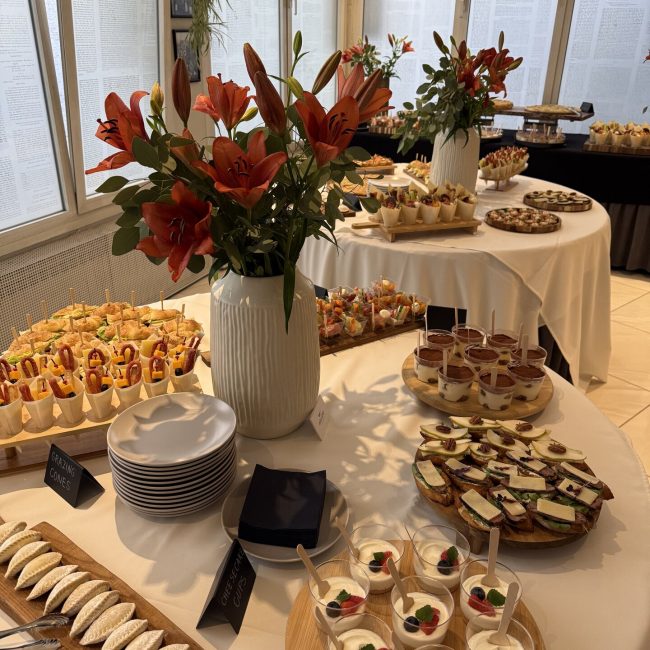 Catering stol s kanapeima, desertima u čašicama i cvijećem
